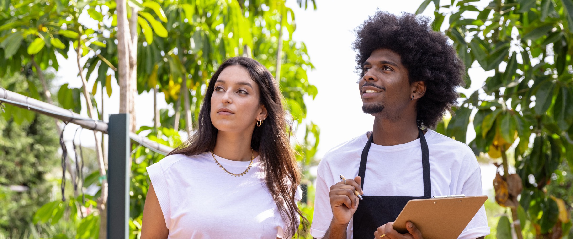 Deux collègues font le point sur une plantation, fiche de suivi en main